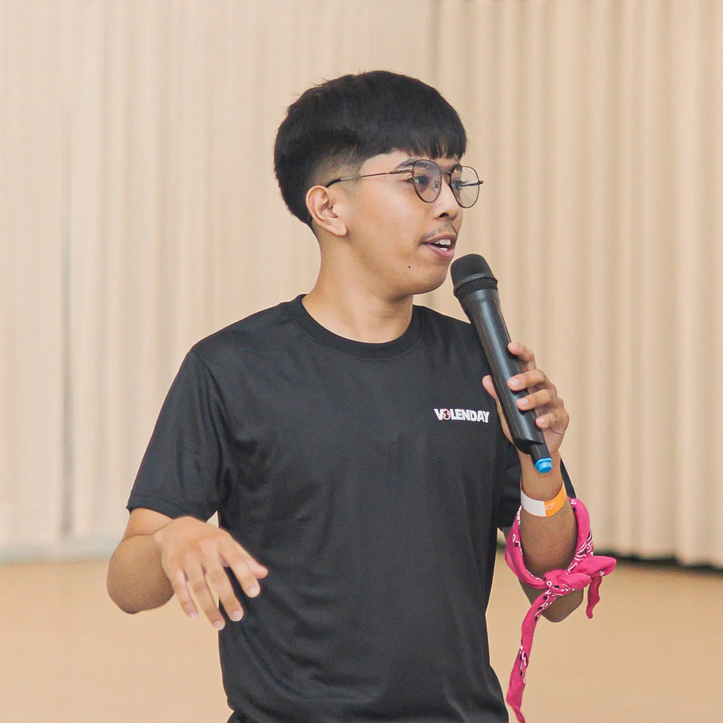 Niel Kurt Garcia speaking into a microphone, wearing a Volenday shirt.